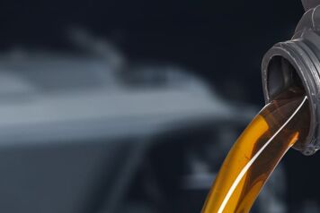 Huile moteur qui coule depuis un bouchon d'un bidon d'huile noir