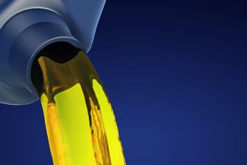 Huile jaune venant d'un bidon versé avec un fond bleu