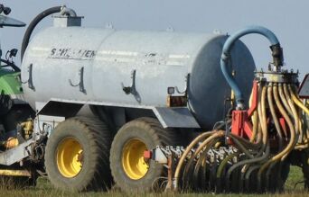 Camion appliquant du lisier dans un champ