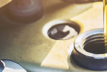 Gros plans huile moteur versé dans la bouchon d'entrée remplissage d'huile d'un moteur